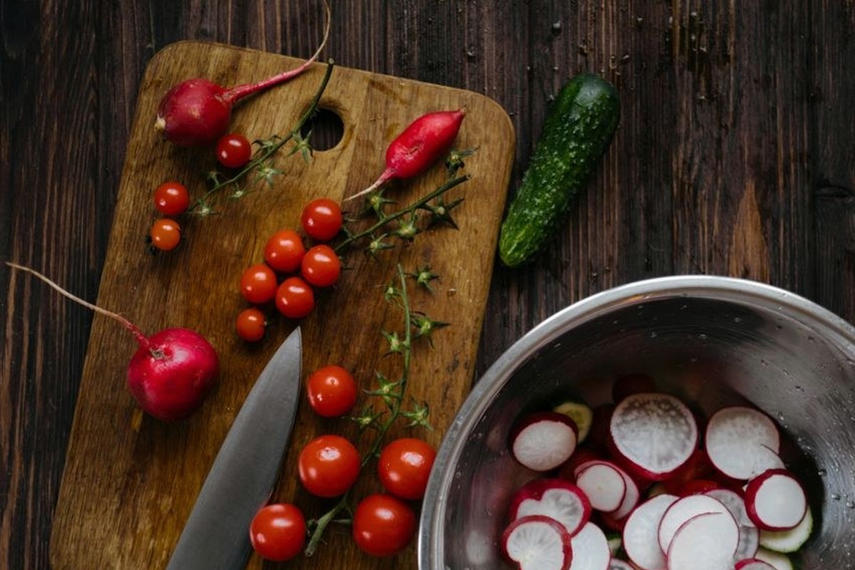 Fresh radishes tomatoes and vegetables on a wooden table
